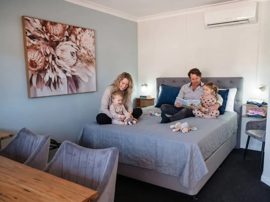 A family reading together on the bed in a Cornwall House family room