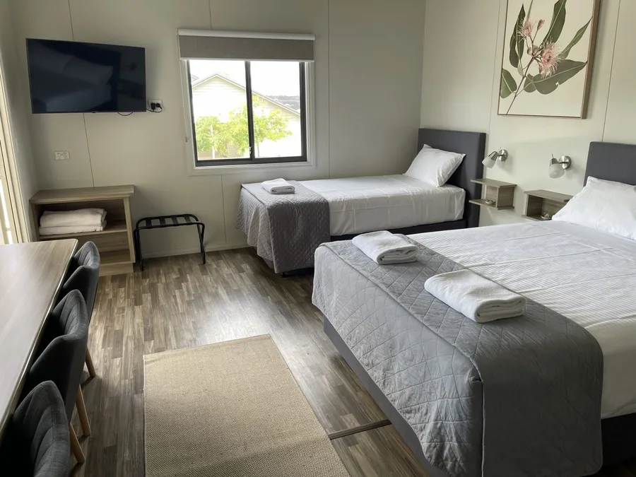 Family room with a queen and a king single bed and a botanical print on the wall